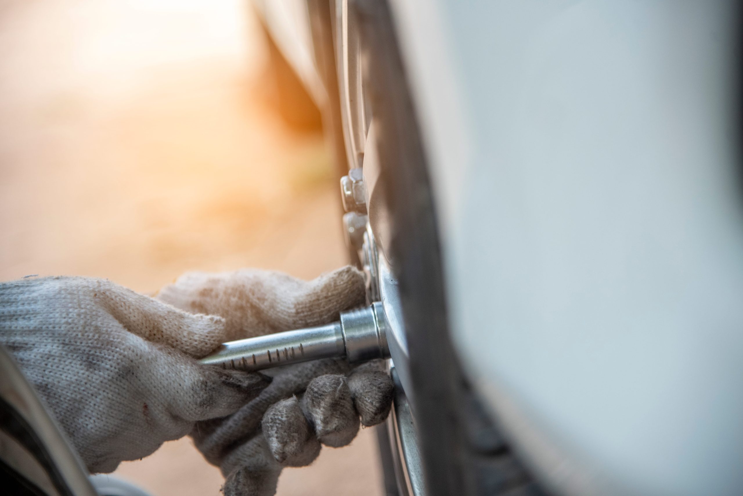 Wheel service: technician using a socket wrench on a lug nut